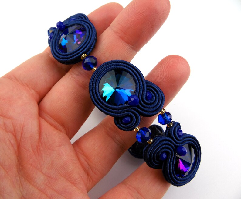 Peut inclure: Un bracelet bleu marine avec un cristal bleu fonc&eacute; et des perles bleues plus petites. Le bracelet est r&eacute;alis&eacute; avec une technique de cordon tress&eacute;.