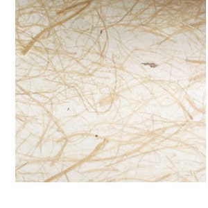 May include: Close-up of handmade paper with a natural, organic texture. The paper has a creamy white base with interwoven strands of tan fibers, creating a unique, rustic appearance. The fibers are irregularly distributed, adding to the paper's artisanal quality.
