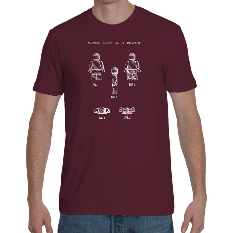 May include: A maroon t-shirt with a white print of a Lego figure patent design. The design includes five figures and the text "U.S. Patent Des. 253,711".