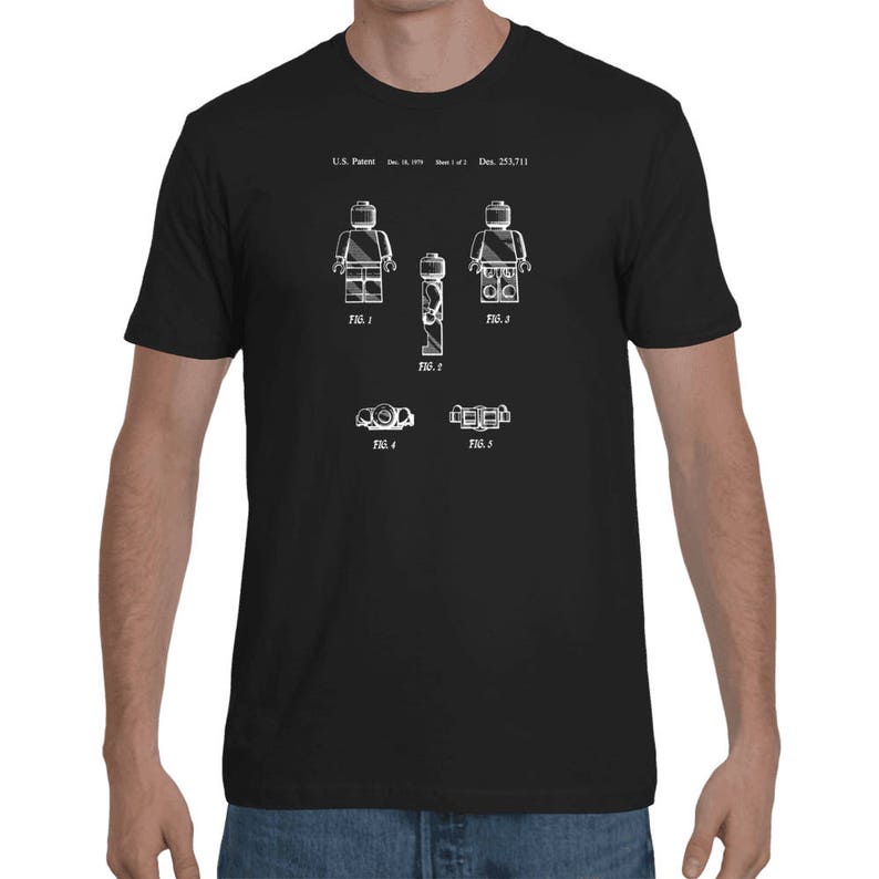 May include: Black t-shirt with a white print of a Lego figure patent design. The design includes five figures and the text "U.S. Patent: Dec. 23, 1977".