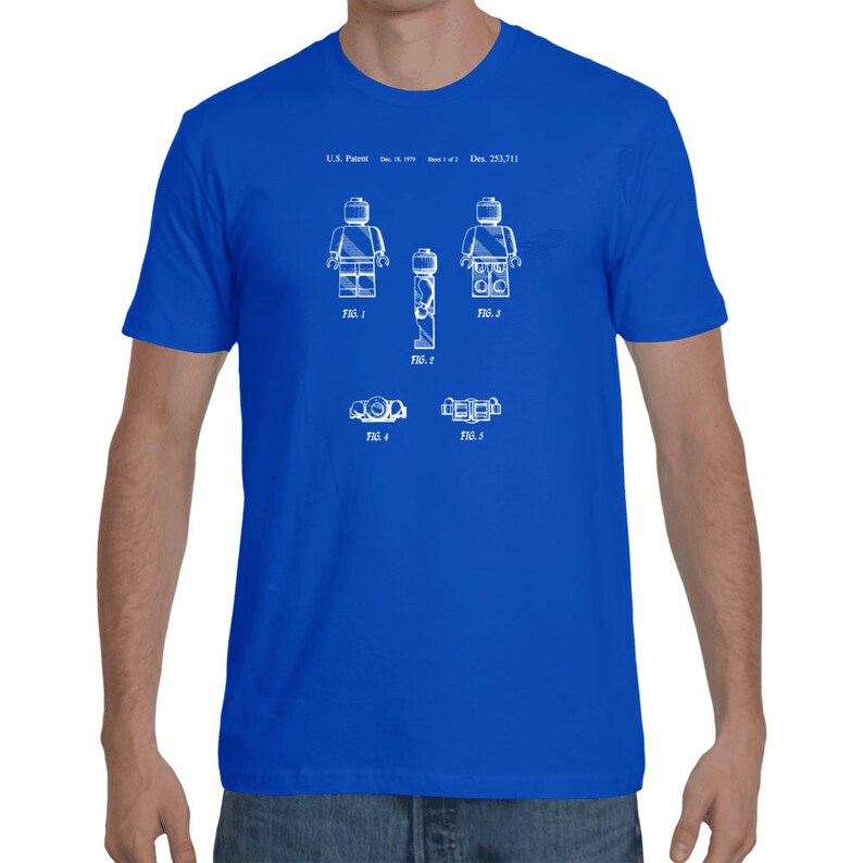 May include: A royal blue t-shirt with a white print of a Lego figure patent design. The patent number is U.S. Patent: Des. 233,711.
