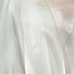 May include: White sheer fabric with a subtle shimmer. The fabric is draped and folded, creating soft, flowing lines.