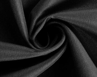 May include: Close-up of black fabric with a swirling pattern. The fabric has a subtle texture and appears to be draped, creating shadows and highlights. The dark color and the way the fabric is arranged suggest a luxurious or elegant material.