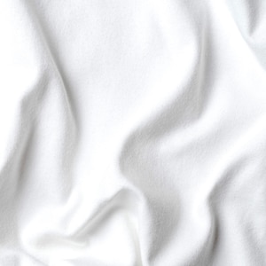 May include: A close-up shot of a white fabric with soft folds and subtle shadows. The fabric appears to be a smooth, possibly cotton or linen material, with a slightly textured surface. The overall effect is clean and minimalist.