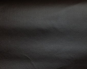 Op de afbeelding: Close-up van een zwarte lederen textuur met een subtiel gepatsteerd patroon.