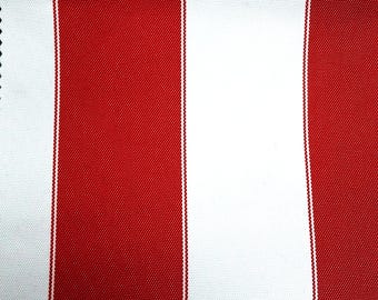 May include: A woven fabric featuring a repeating pattern of wide, vertical red stripes alternating with wide, vertical white stripes. The texture of the material is visible, showing a consistent, tight weave throughout the entire surface area.