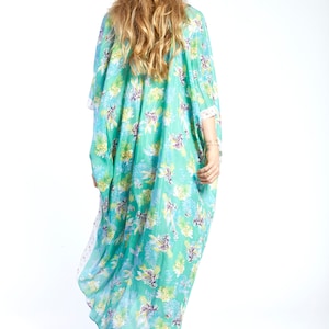 May include: A long, flowing turquoise kaftan with a floral print. The kaftan has a loose, comfortable fit and is perfect for warm weather.