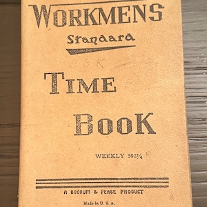 Pode incluir: Um livro de tempo encadernado em couro castanho com o texto "WORKMENS Standard TIME Book WEEKLY 592 1/4 A BOONUM & PEASE PRODUCT Made in U.S.A."
