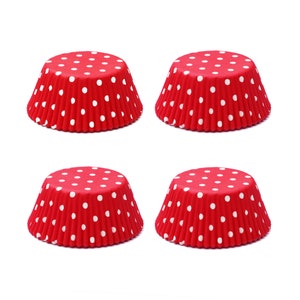 May include: Four red cupcake liners with white polka dots. The liners are made of paper and are designed to be used in a muffin tin.
