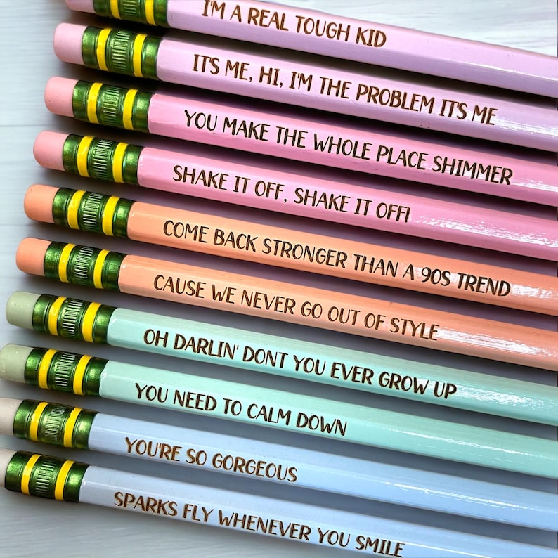 K&ouml;nnte beinhalten: Ein Set aus zehn Bleistiften mit verschiedenen K&ouml;rperfarben und goldenen Schriftz&uuml;gen. Die Bleistifte tragen Zitate aus beliebten Songs, darunter "I'm a real tough kid", "Shake it off, shake it off" und "You're so gorgeous".