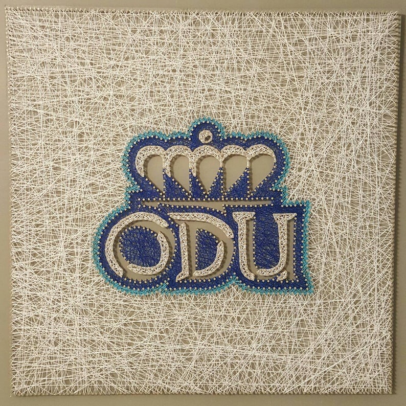 Peut inclure: Art de fil repr&eacute;sentant les lettres ODU avec une couronne au-dessus. Les lettres sont bleues et la couronne est blanche. Le fond est une grille blanche.