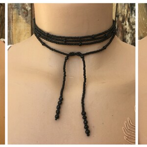 May include: Three beaded choker necklaces with adjustable ties. The first necklace is turquoise blue, the second is black, and the third is multi-coloured.