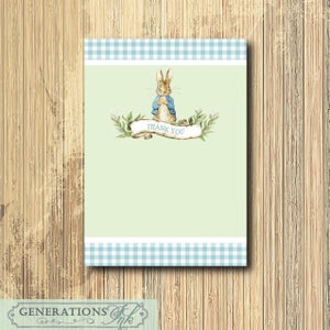 May include: A green thank you card with a blue and white gingham border. The card features a watercolor illustration of Peter Rabbit wearing a blue jacket and standing on a scroll with the words "Thank You".