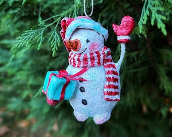 Bonhomme de neige mignon avec un cadeau et un chapeau de Père Noël OOAK Ornement en papier mâché fait à la main et figurine peinte à la main décoration d'arbre de Noël