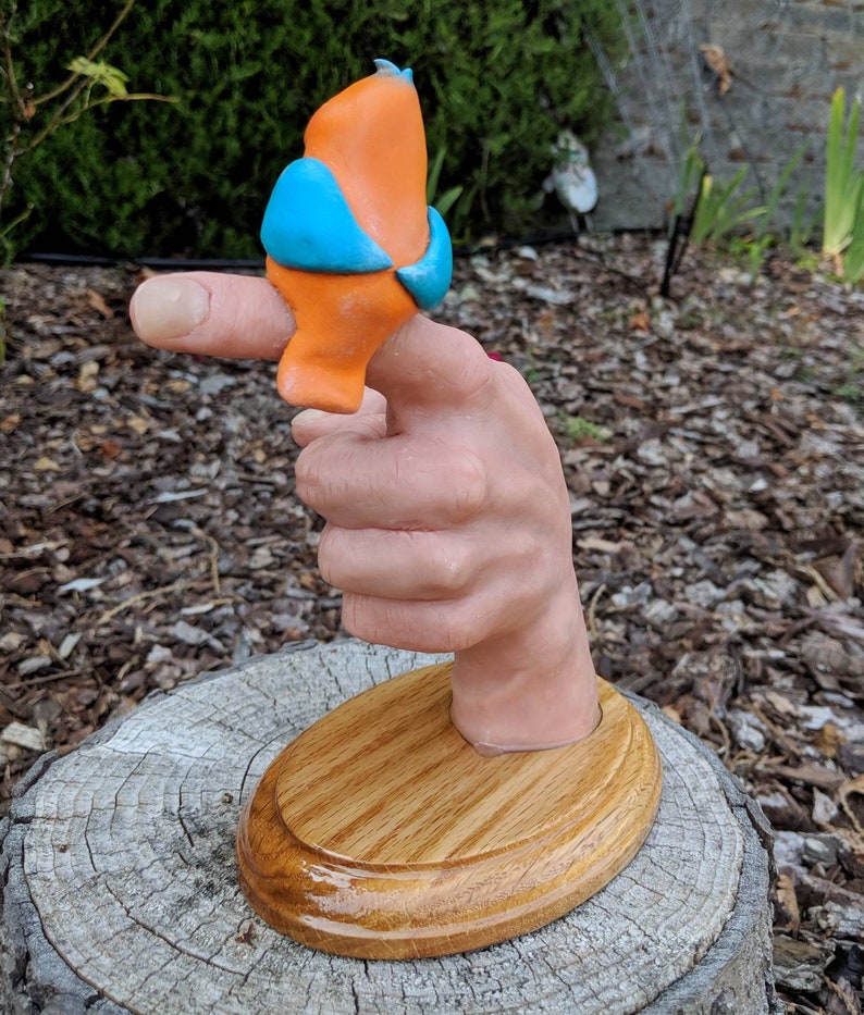 Realistic hand with a cartoonish aNGie Bird handmade sculpture OOAK on wooden oak base