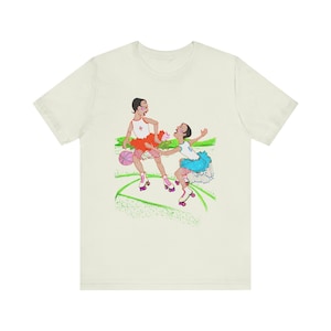 Może przedstawiać: Biały t-shirt z kolorową ilustracją dwóch osób na rolkach. Osoby te są ubrane w kolorowe stroje i trzymają piłkę do koszykówki.