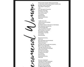 May include: A framed print featuring the poem "Phenomenal Woman" by Maya Angelou. The title is written vertically in elegant script, with the poem's text in a clear, readable font. The frame is black.