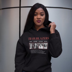 May include: Black hoodie with the word "TRAILBLAZERS" in red text. Below the text are images of four women. The hoodie also features the words "LEGACY, LEADER, ACTIVIST, JUSTICE". Quotes are printed below the images.