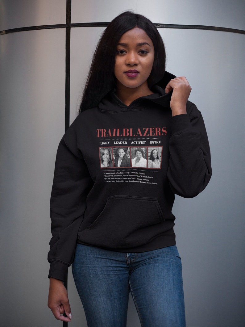 May include: Black hoodie with the word "TRAILBLAZERS" in red text. Below the text are images of four women. The hoodie also features the words "LEGACY, LEADER, ACTIVIST, JUSTICE". Quotes are printed below the images.
