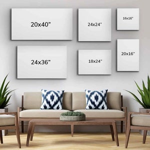 May include: A living room interior with a beige sofa and two throw pillows with a black and white geometric pattern. There are five white canvases on the wall with different dimensions written on them: 20x40", 24x36", 24x24", 18x24", and 20x16".