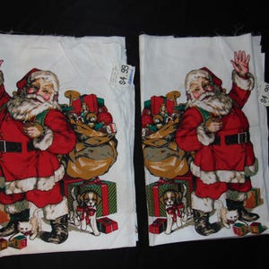 May include: Two white fabric panels with a Christmas theme. Each panel features a red and white Santa Claus holding a bag of gifts. The Santa Claus is waving and smiling. The panels have a price tag that says "$4.99".