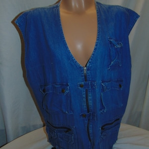 Puede incluir: Un chaleco vaquero azul con múltiples bolsillos y cierre de cremallera.