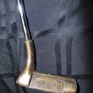 以下が含まれることがあります： ブロンズ色のヘッドとクロムシャフトを備えた、ヴィンテージのゴルフパター。 パターヘッドには「Allstate」の文字が刻まれています。 このクラブは、グリーンの上で正確なパッティングができるように設計されています。