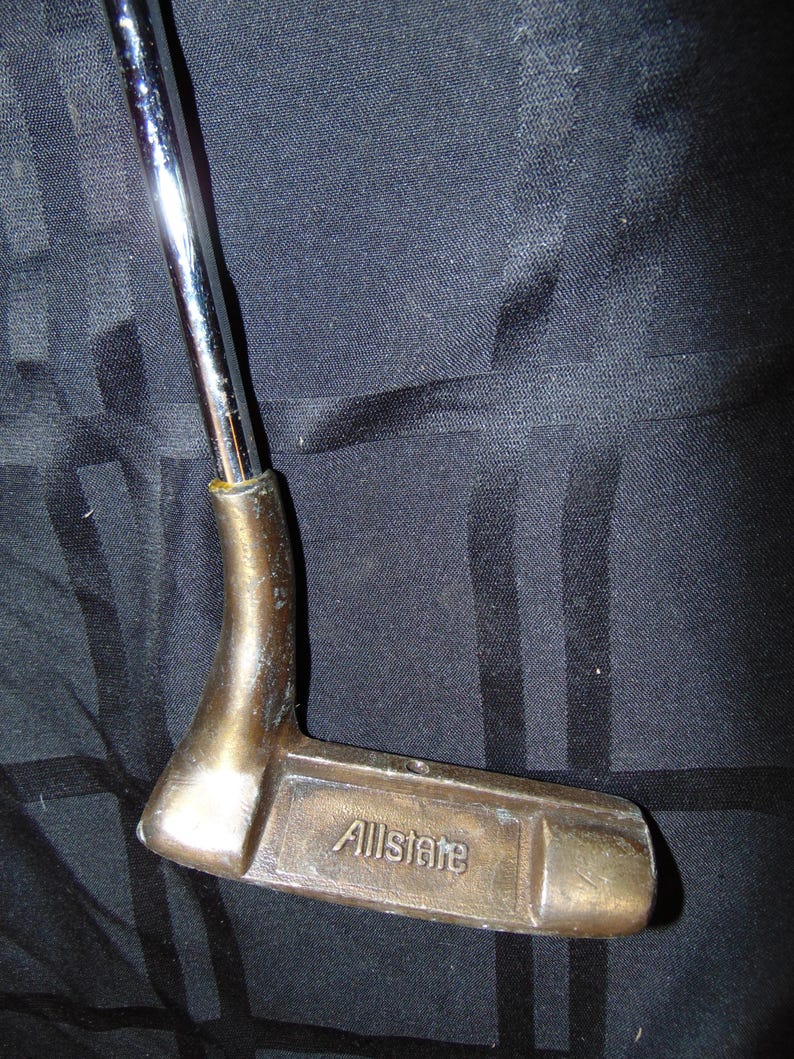 以下が含まれることがあります： ブロンズ色のヘッドとクロムシャフトを備えた、ヴィンテージのゴルフパター。 パターヘッドには「Allstate」の文字が刻まれています。 このクラブは、グリーンの上で正確なパッティングができるように設計されています。