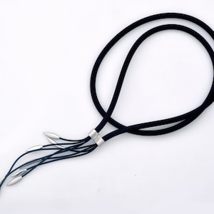 May include: A black cord necklace with a silver clasp and multiple silver strands hanging from the bottom.