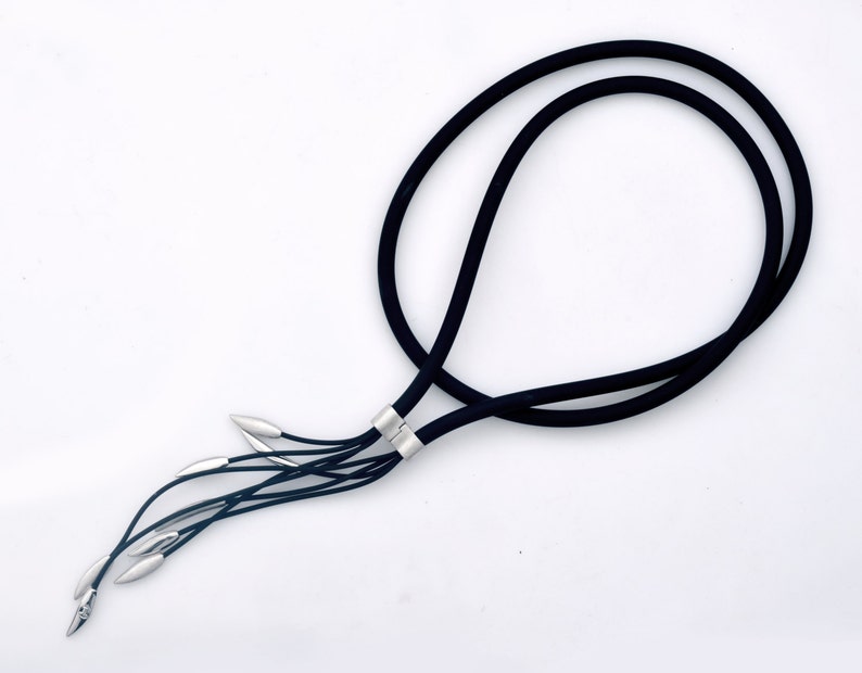 May include: A black cord necklace with a silver clasp and multiple silver strands hanging from the bottom.
