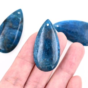 May include: Three teardrop-shaped blue gemstone pendants with a hole drilled at the top for stringing.