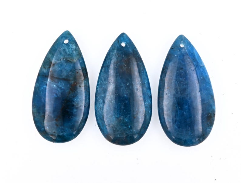 May include: Three teardrop-shaped blue agate pendants with a hole at the top for stringing.