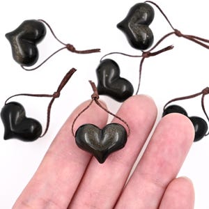Puede incluir: Seis colgantes de piedra de sol negra en forma de coraz&oacute;n con cordones marrones. Los colgantes miden aproximadamente 2,5 cm.