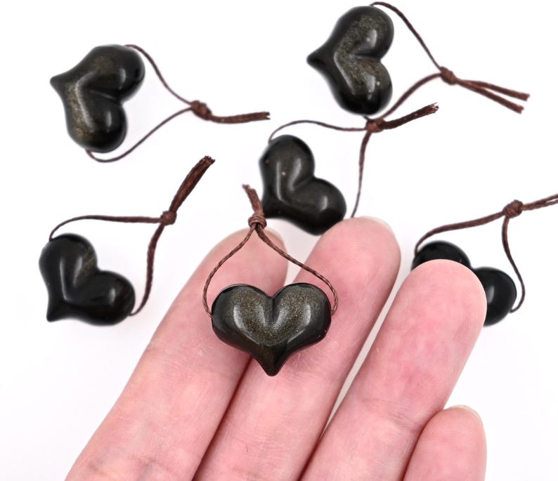 Puede incluir: Seis colgantes de piedra de sol negra en forma de coraz&oacute;n con cordones marrones. Los colgantes miden aproximadamente 2,5 cm.