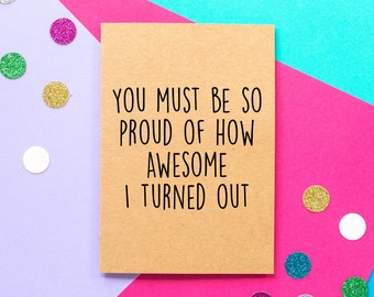 May include: A brown card with the text "You must be so proud of how awesome I turned out" on a pink and purple background with glitter confetti.