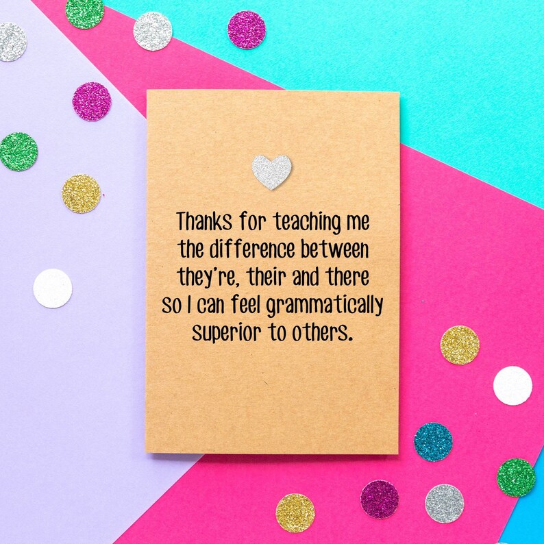 May include: A brown card with a silver glitter heart and the text "Thanks for teaching me the difference between they're, their and there so I can feel grammatically superior to others."