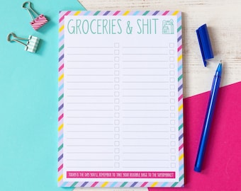 Op de afbeelding: Een notitieblok met de tekst "GROCERIES & SHIT" in het groen, met een lijst met selectievakjes. Het notitieblok heeft een kleurrijke gestreepte rand en een blauwe pen. De tekst "TODAY IS THE DAY YOU'LL REMEMBER TO TAKE YOUR REUSABLE BAGS TO THE SUPERMARKET" staat onderaan.