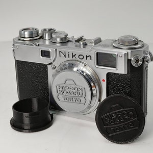 Custom Petrakla Nikon Nippon Kogaku body cap, one grey or black.
