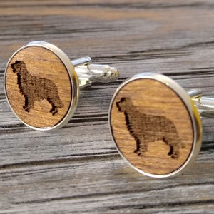 May include: A pair of wooden cufflinks with a silver finish. Each cufflink features a laser-engraved silhouette of a dog.