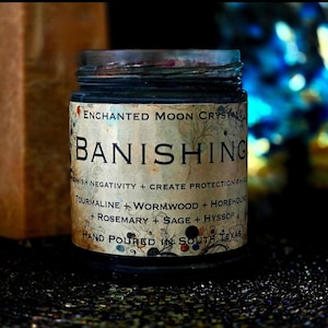 Handmade Banishing intention candle in a clear glass jar with dark wax and a vintage-style label. This spiritual candle is created for banishing unwanted energy, energetic clearing, cutting cords and reclaiming your space with protection and intention.