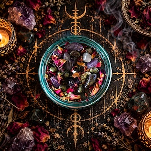 Overhead view of the Someone Fucked Up ritual candle, displaying dark wax decorated with colorful dried flower petals, bloodstone, amethyst, and botanical toppings. The turquoise glass jar sits within an intricate golden occult circle surrounded by dark roses, purple crystals, mystical symbols, and warm candlelight. An atmospheric black magic candle presentation inspired by witchcraft and spiritual defense.