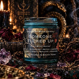 Someone Fucked Up black magic intention candle by Enchanted Moon Crystal, featuring a turquoise glass jar with a dark gothic label. Displayed on an elaborate witchcraft altar surrounded by amethyst crystals, dried burgundy roses, golden occult decorations, and curling incense smoke. A dramatic ritual candle inspired by hexing, banishing, energetic protection, and reclaiming personal power.