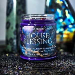 Pu&ograve; includere: Una candela in barattolo di vetro viola con la scritta "HOUSE BLESSING" in bianco. L'etichetta presenta un design blu scuro e viola con le parole "ENCHANTED MOON CRYSTAL" e i dettagli degli ingredienti. La candela &egrave; versata a mano nel Texas del Sud.
