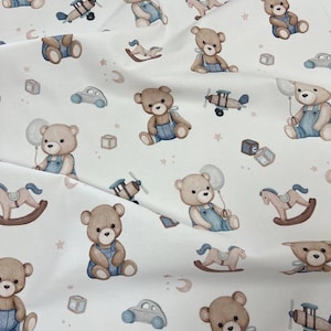 Pu&ograve; includere: Tessuto bianco con un motivo ripetuto di orsacchiotti con salopette blu, aeroplani, cavalli a dondolo, macchinine e blocchi alfabetici. Gli orsi tengono in mano dei palloncini. Il disegno comprende stelle e mezzelune.