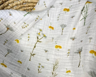 May include: A white muslin baby blanket with a delicate floral pattern featuring yellow flowers and green stems. The blanket is soft and lightweight, perfect for swaddling or cuddling.
