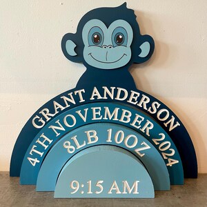 May include: Blue and white wooden baby announcement sign with a monkey cutout. The sign reads "Grant Anderson 4th November 2024 8lb 10oz 9:15 AM".