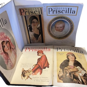 May include: A collection of five vintage Modern Priscilla magazines featuring illustrated covers from the 1920s. The covers display various portraits of people, including a child, and text such as December Nineteen Twenty Seven and Christmas Issue.