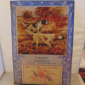 May include: Vintage calendar print featuring two hunting dogs in a field, with a blue floral border. The print includes the text "OLSON'S MARKET" and a holiday greeting that reads "A Merry Christmas 1941 A Happy New Year!"