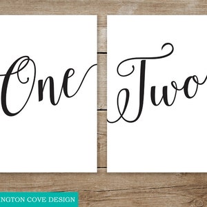 Puede incluir: Dos carteles imprimibles con las palabras "Uno" y "Dos" escritas en letra cursiva.