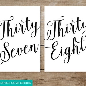 May include: Two white signs with black calligraphy. The first sign says "Thirty Seven" and the second sign says "Thirty Eight".